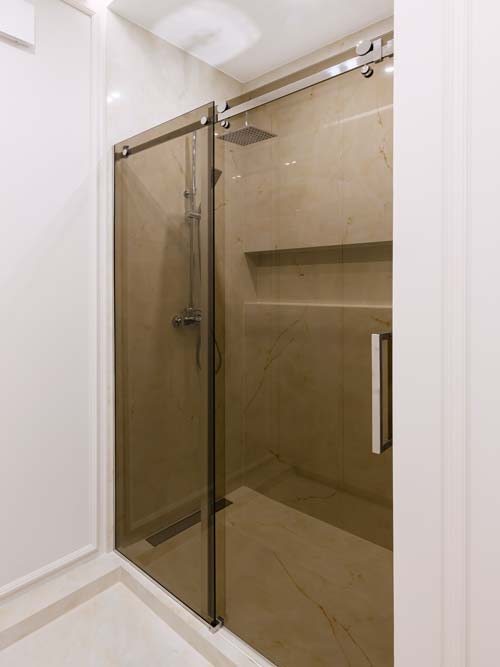 Kabina wnękowa z przesuwnymi drzwiami z brązowego szkła antisol.