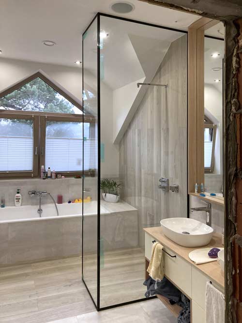 Kabina prysznicowa walk-in od podłogi do sufitu z czarnymi listwami na krawędziach. Szklarz Radzymin