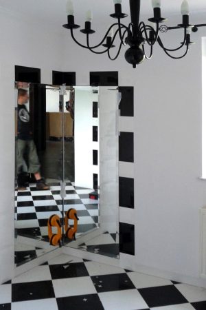 Dwa lustra wklejone na ścianie w rogu łazienki
