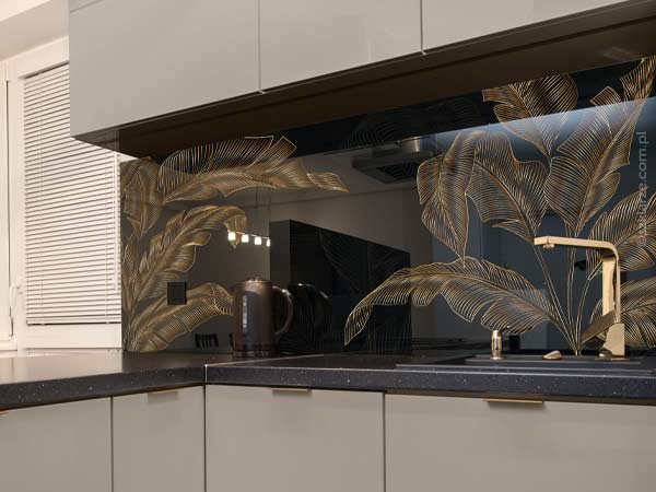 Czarne szkoło do kuchni z motywem złotych liści w nowoczesnej szarej kuchni